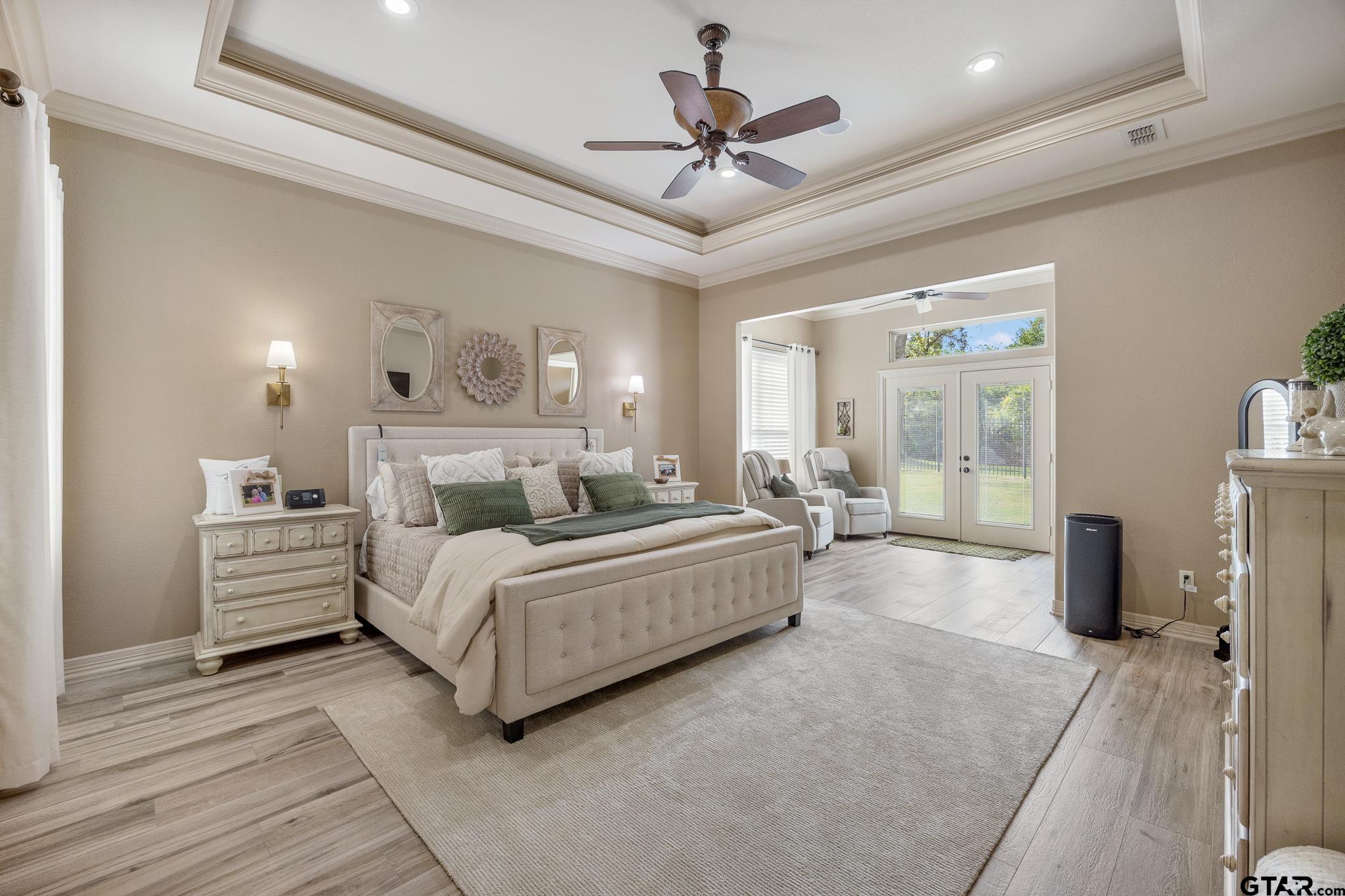 5875 Stonegate Trail Tyler, TX 75703 - Photo 14 of 47 a spacious bedroom with a bed a couch and a chandelier