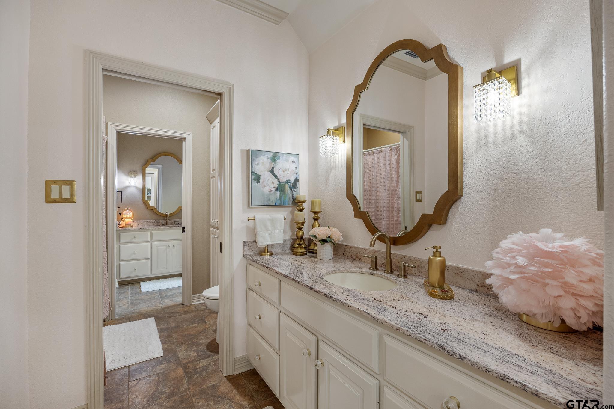 5875 Stonegate Trail Tyler, TX 75703 - Photo 25 of 47 a bathroom with a double vanity sink and a mirror