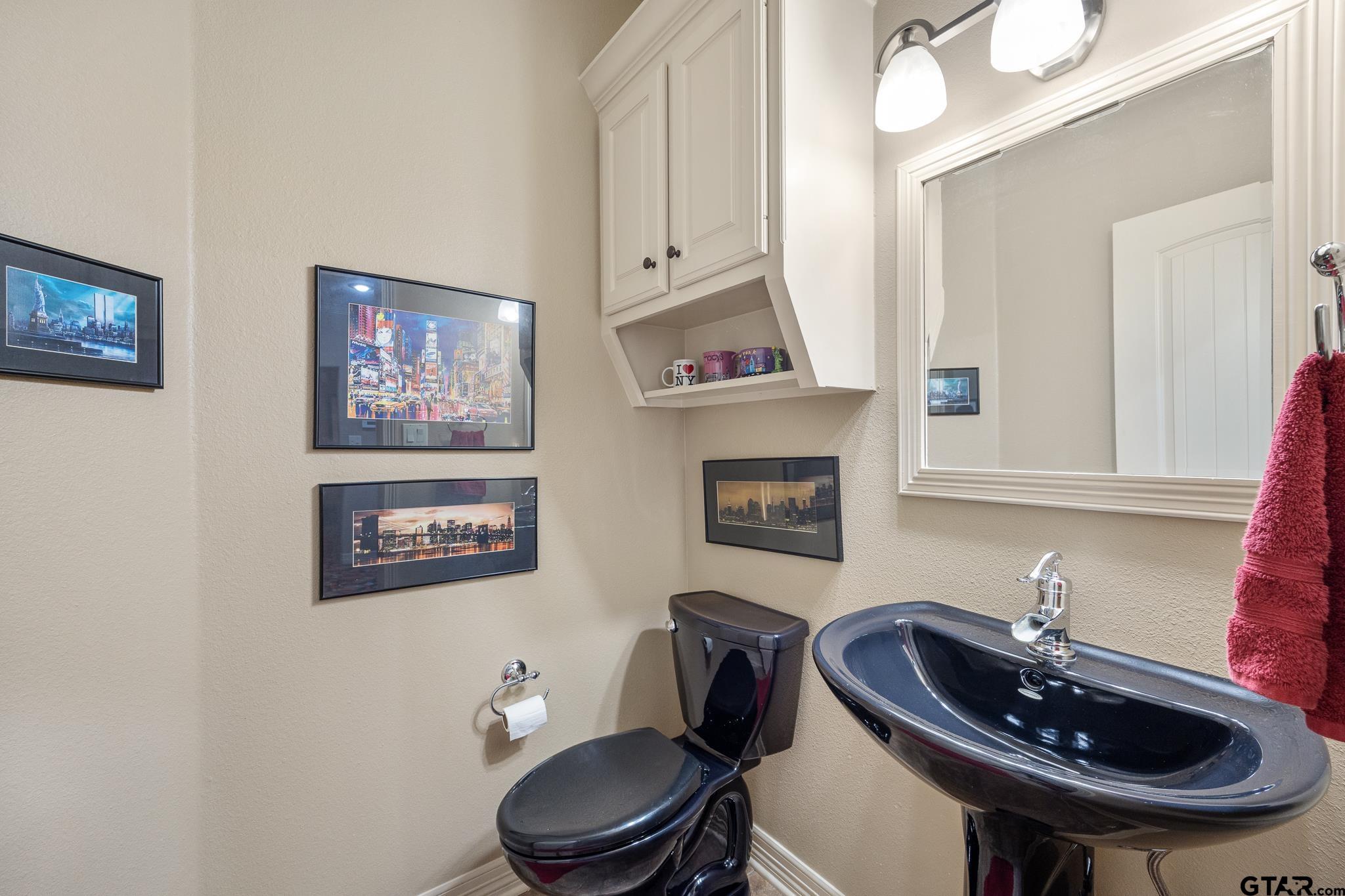 5875 Stonegate Trail Tyler, TX 75703 - Photo 30 of 47 a bathroom with a toilet a sink and a mirror