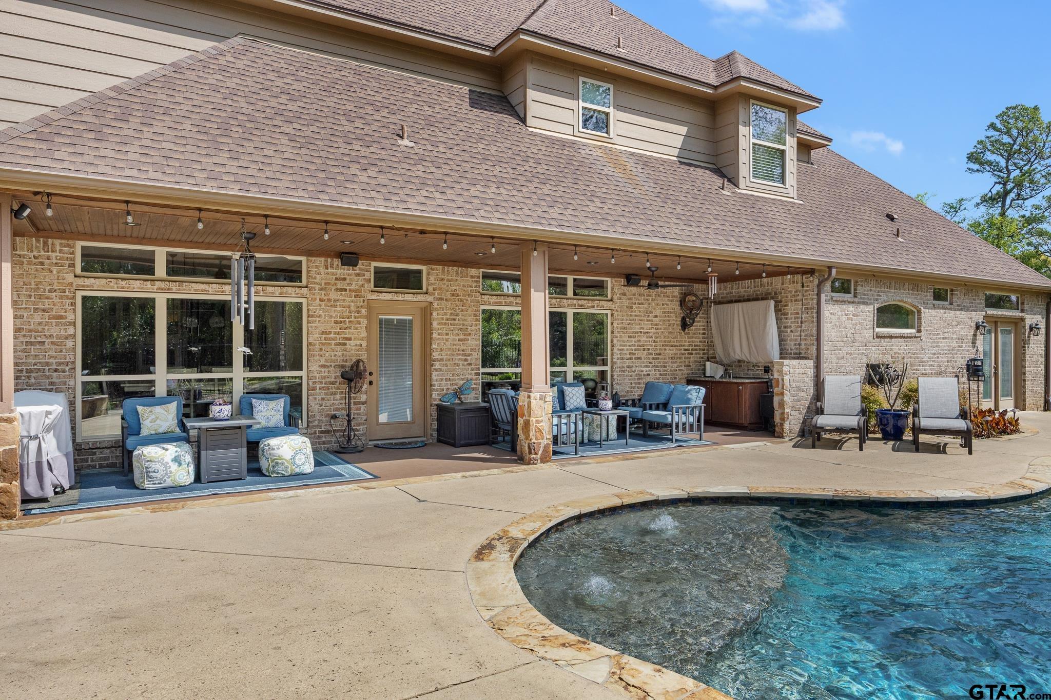 5875 Stonegate Trail Tyler, TX 75703 - Photo 34 of 47 a view of a house with patio furniture and floor to ceiling window