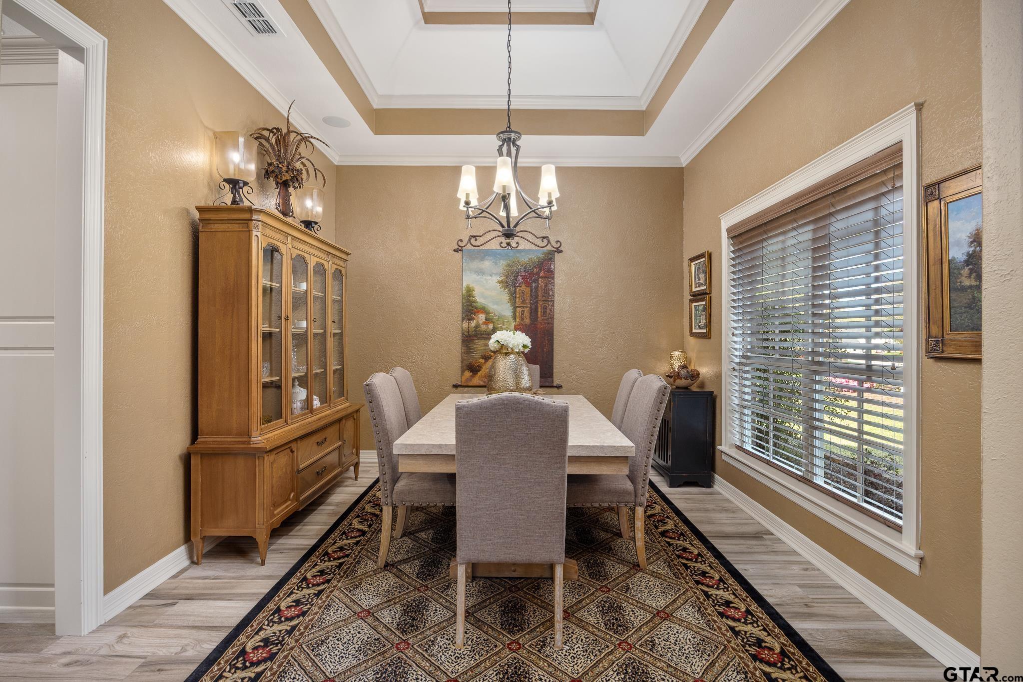 5875 Stonegate Trail Tyler, TX 75703 - Photo 6 of 47 a dining room with furniture a chandelier and wooden floor