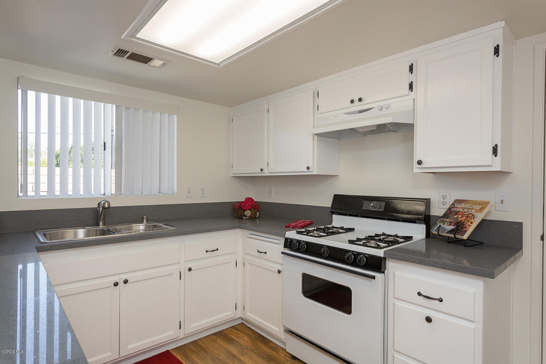 4516 Apricot Road, Unit B Simi Valley, CA 93063 - Photo 3 of 24 a kitchen with granite countertop white cabinets sink and white appliances
