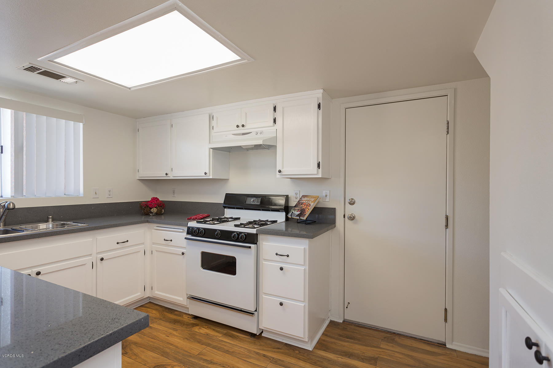 4516 Apricot Road, Unit B Simi Valley, CA 93063 - Photo 5 of 24 a kitchen with cabinets appliances and wooden floor