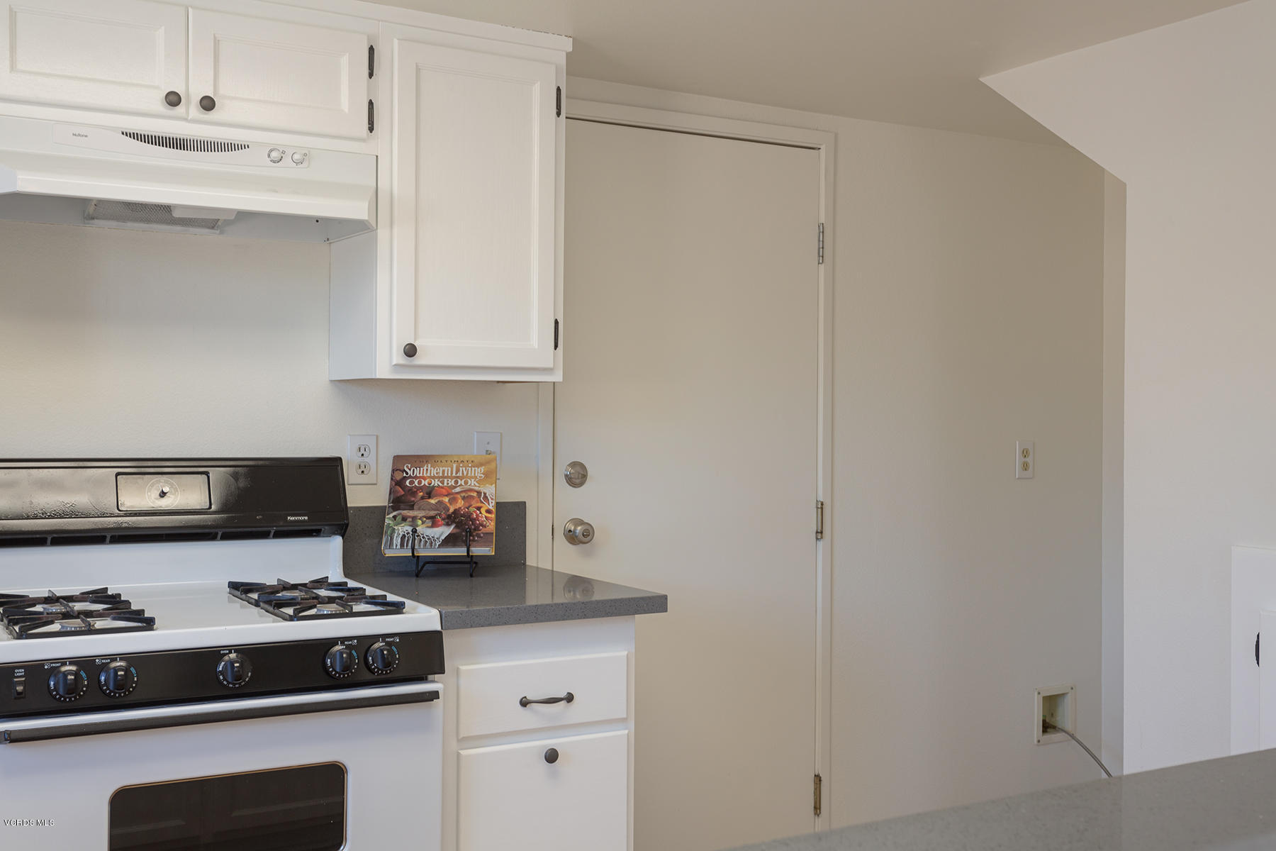 4516 Apricot Road, Unit B Simi Valley, CA 93063 - Photo 7 of 24 a kitchen with a stove and white cabinets