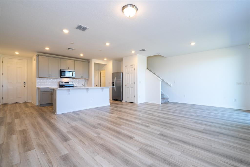 4549 Burrowing Owl Loop St. Cloud, FL 34772 - Photo 20 of 77 a view of kitchen with kitchen island microwave and wooden floor