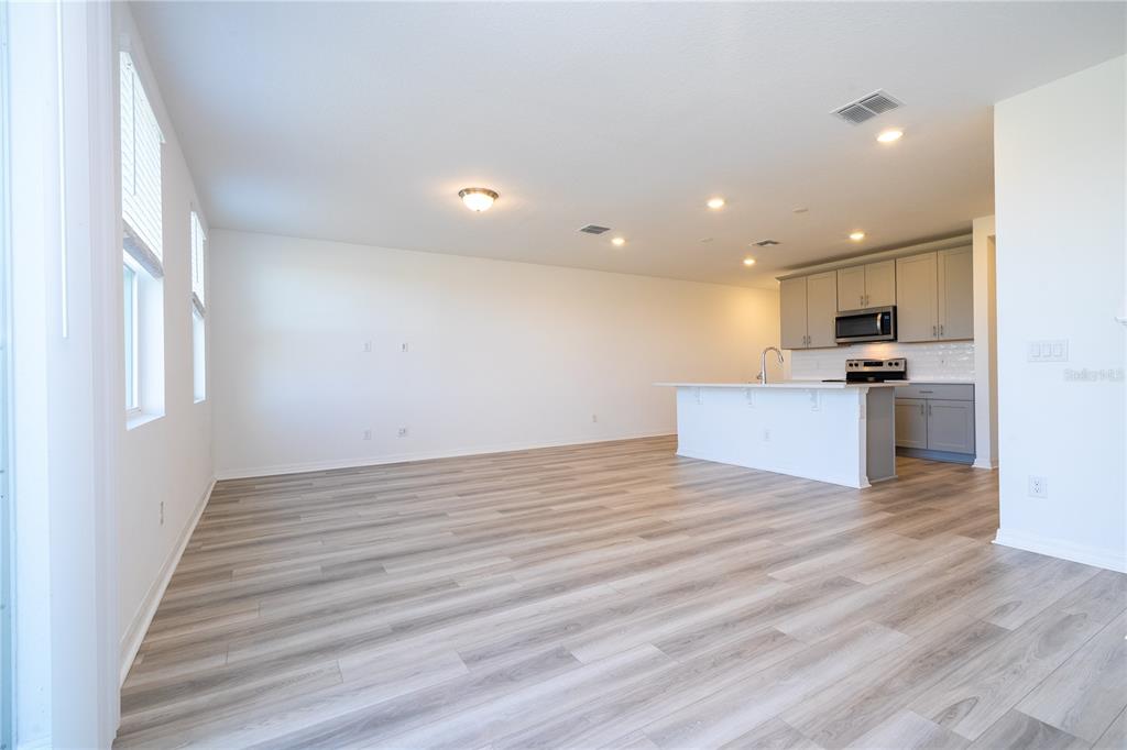 4549 Burrowing Owl Loop St. Cloud, FL 34772 - Photo 21 of 77 a view of a kitchen with a sink and dishwasher wooden floor
