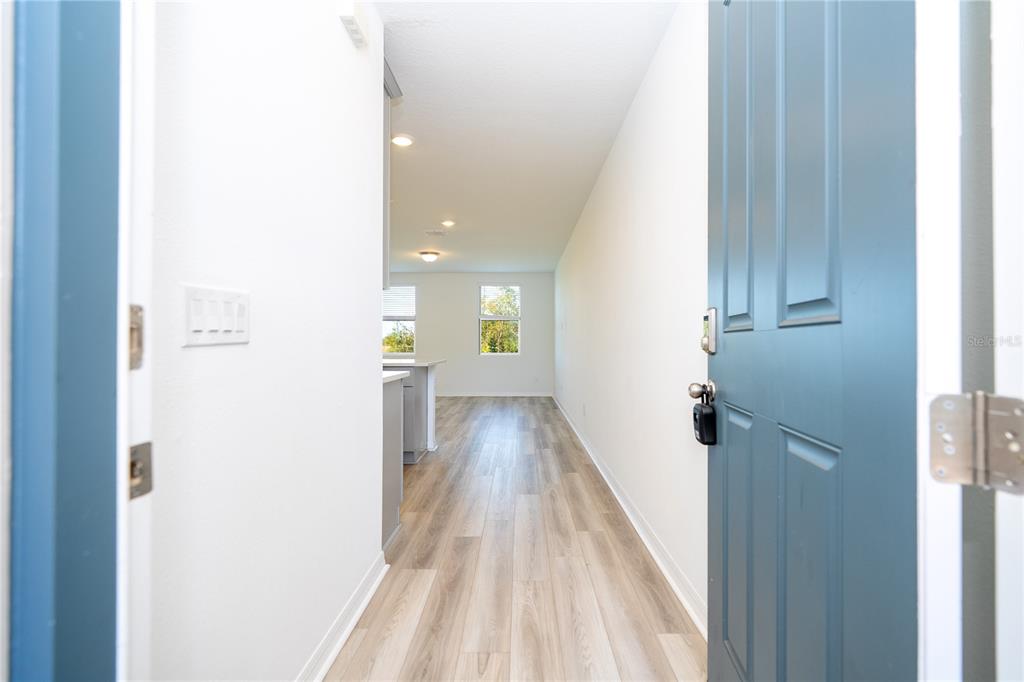 4549 Burrowing Owl Loop St. Cloud, FL 34772 - Photo 4 of 77 a view of a hallway with wooden floor and staircase