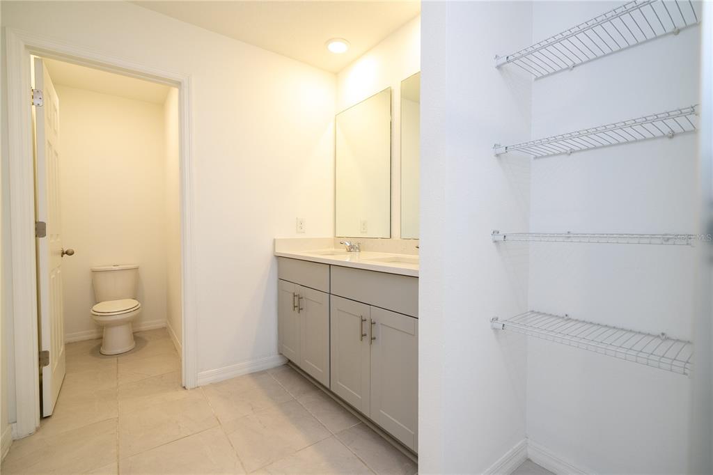 4549 Burrowing Owl Loop St. Cloud, FL 34772 - Photo 55 of 77 a spacious bathroom with a granite countertop sink toilet and shower