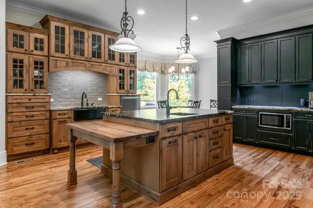 a kitchen with stainless steel appliances granite countertop a stove a refrigerator and a wooden cabinets