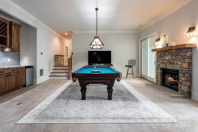 a living room with furniture a fireplace and a chandelier