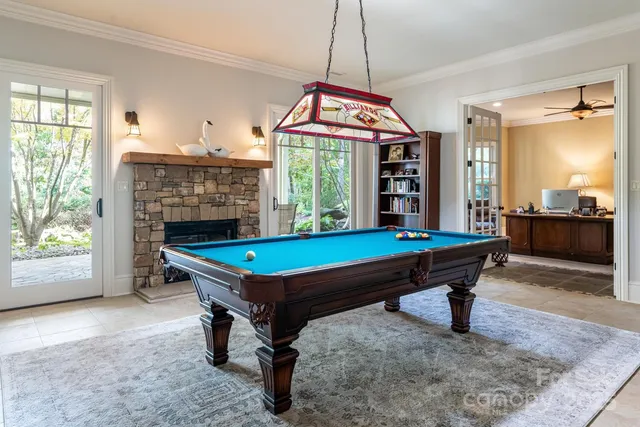 a room with pool table and windows