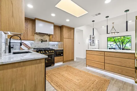 a kitchen with stainless steel appliances granite countertop a stove a sink and a refrigerator