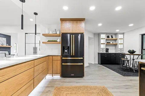 a kitchen with stainless steel appliances granite countertop a refrigerator and a sink