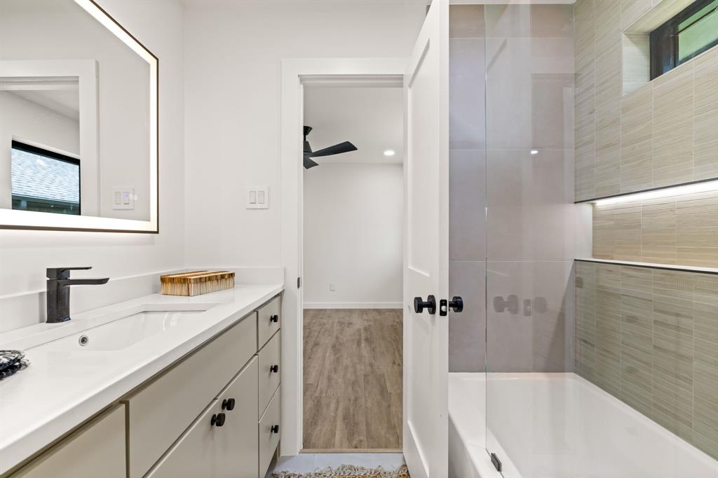 1112 Chesterton Drive Richardson, TX 75080 - Photo 22 of 31 a bathroom with a tub sink vanity granite and mirror