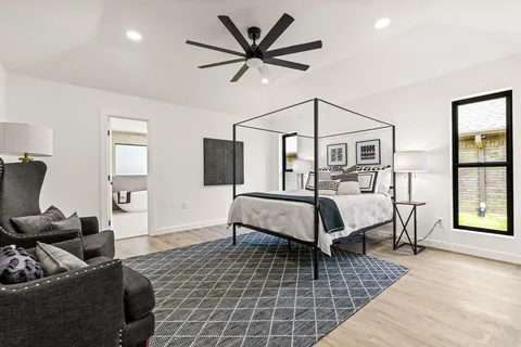 a bedroom with a bed couches and window