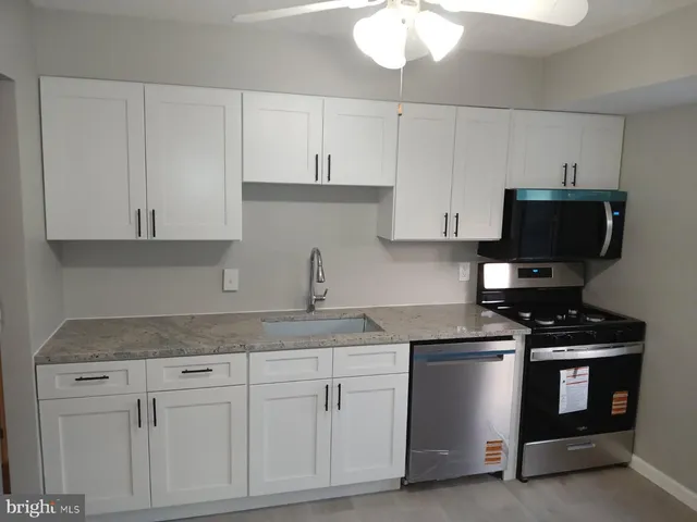 a kitchen with white cabinets and appliances