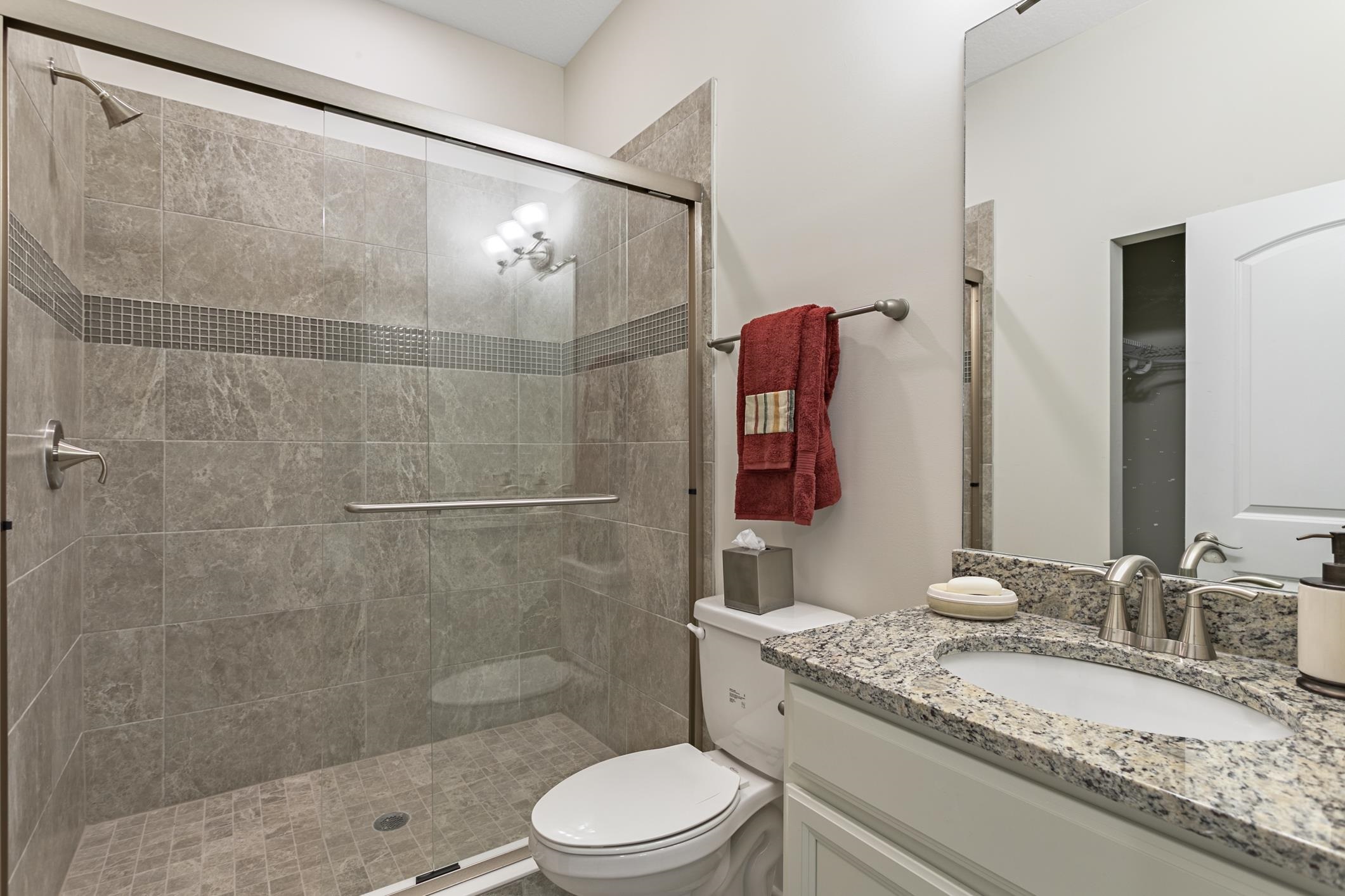 254 Grand Ravine Drive St. Augustine, FL 32086 - Photo 29 of 40 a bathroom with a granite countertop sink toilet and shower