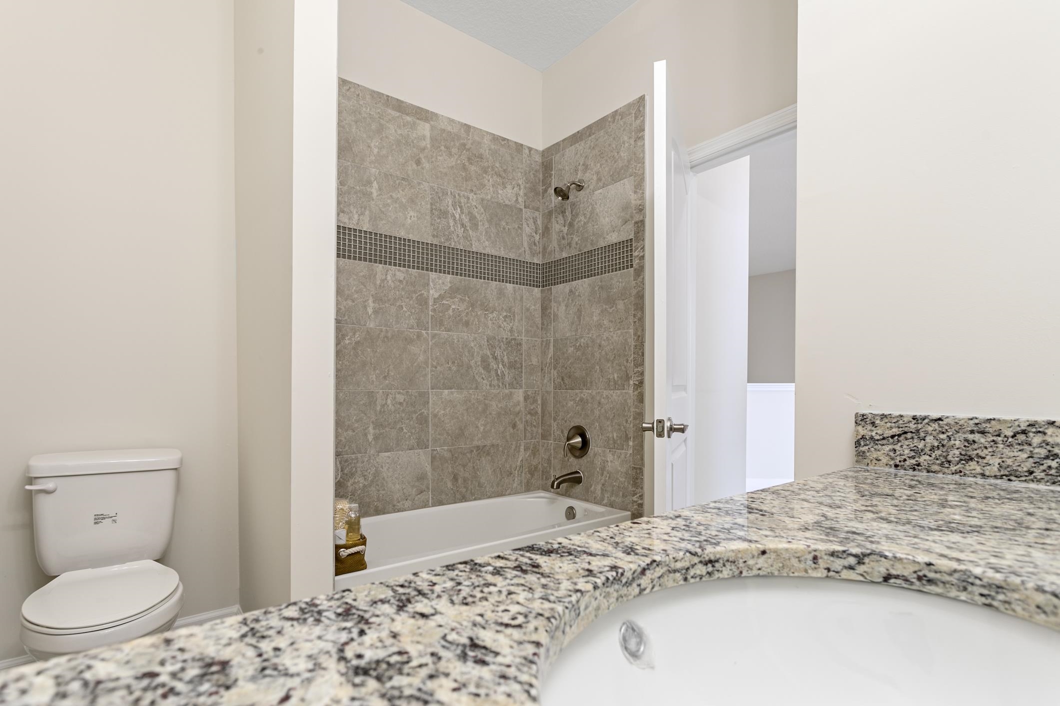 254 Grand Ravine Drive St. Augustine, FL 32086 - Photo 32 of 40 a bathroom with a granite countertop sink a toilet and shower