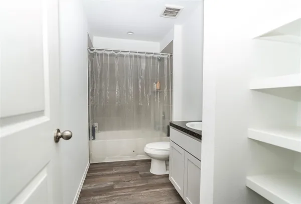 a bathroom with a shower a toilet and a sink