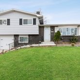 a front view of a house with a yard and trees
