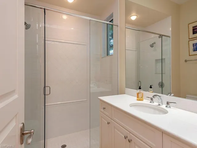 a bathroom with a shower sink vanity and mirror