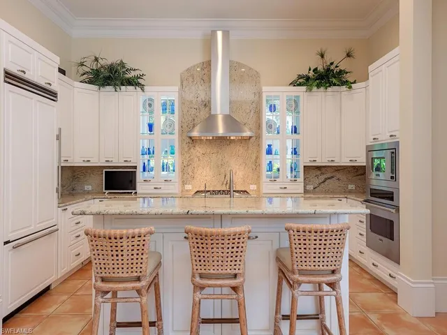 a kitchen with stainless steel appliances kitchen island granite countertop a stove a sink and a refrigerator