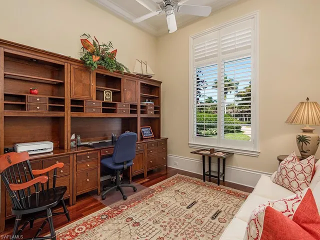 a view of a workspace with furniture and a window