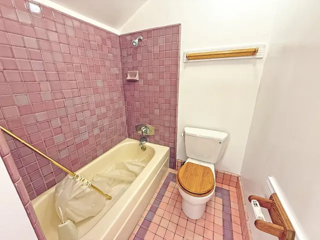 a bathroom with a granite countertop bathtub and a toilet