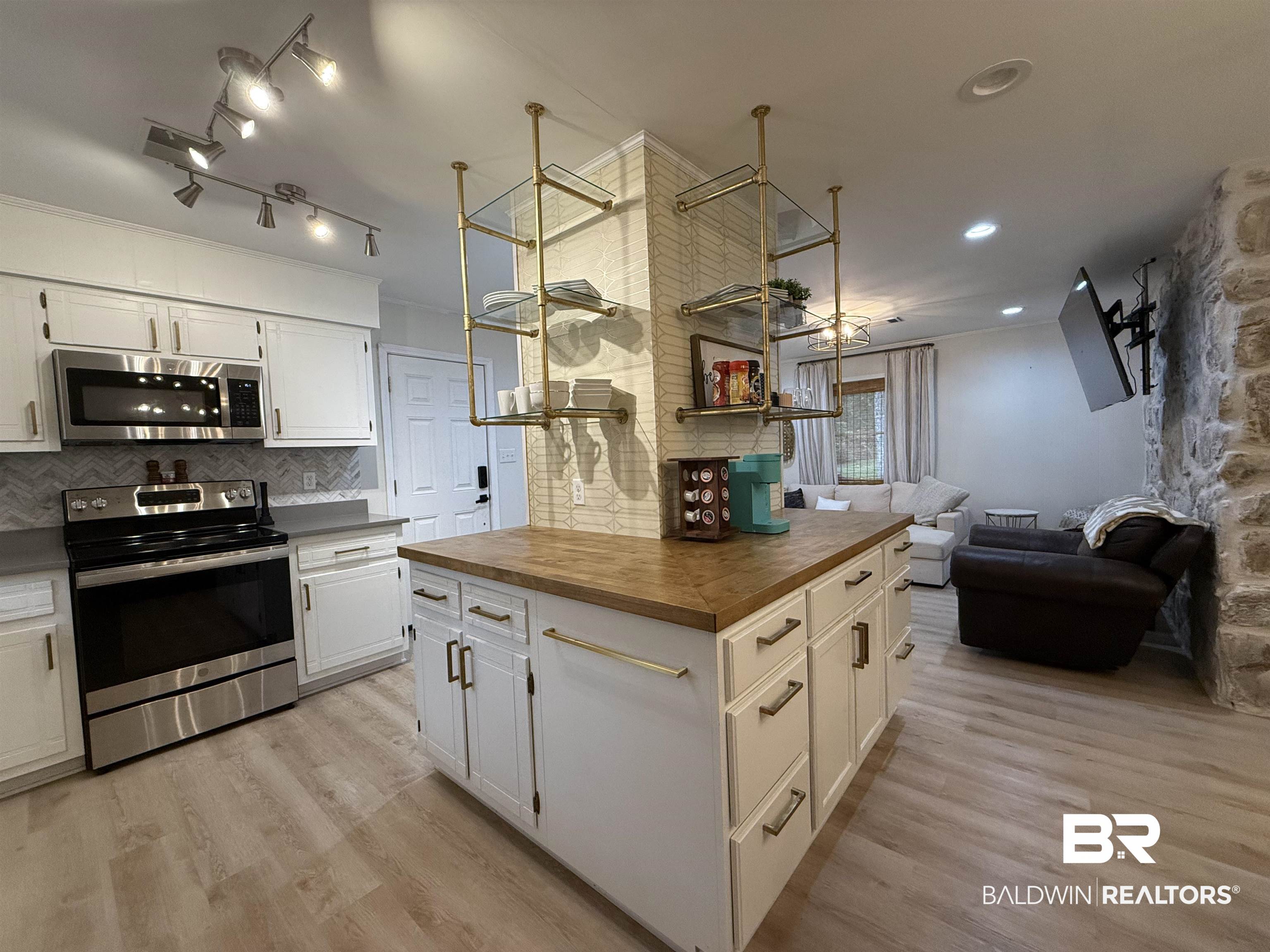 90 Florida Street Monroeville, AL 36460 - Photo 12 of 31 Kitchen with white cabinets, tasteful backsplash, light hardwood / wood-style flooring, quartz and wooden counters, and stainless steel appliances