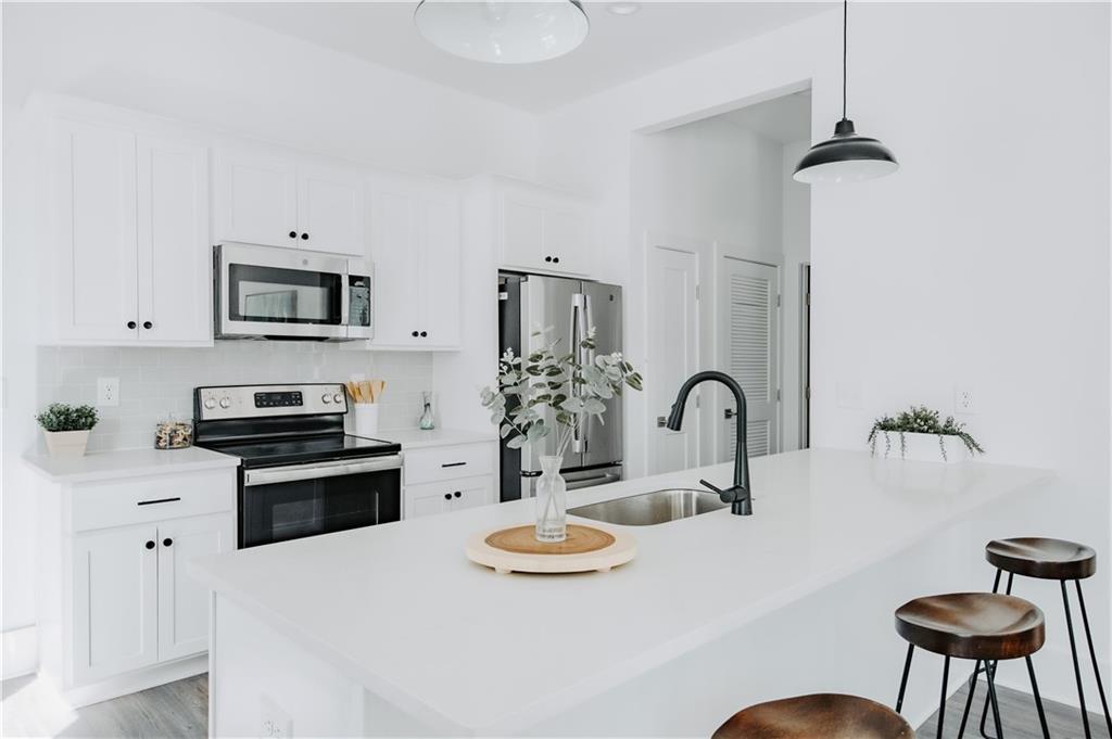 123 Mayson Avenue Northeast, Unit C Atlanta, GA 30307 - Photo 3 of 21 a kitchen with stainless steel appliances kitchen island a table and chairs in it