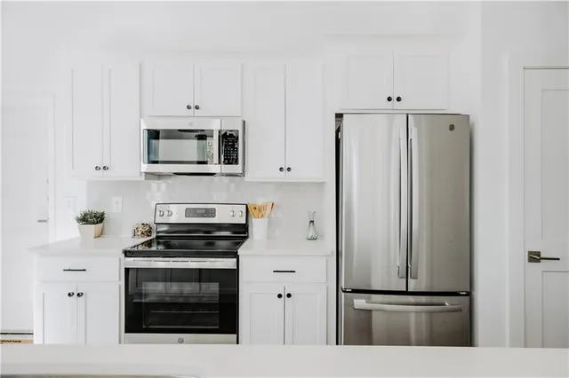 a kitchen with cabinets and stainless steel appliances