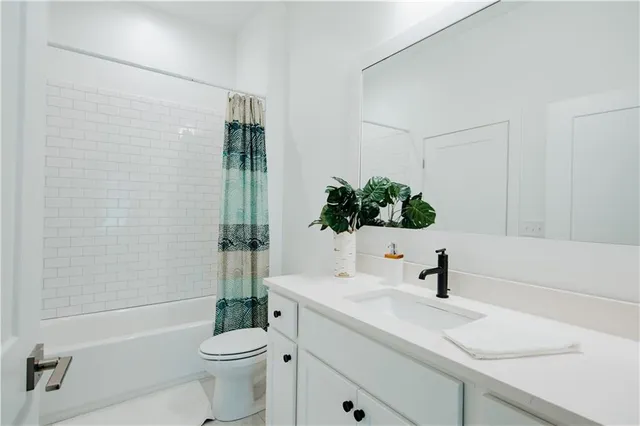 a bathroom with a sink a toilet a mirror a vanity and shower