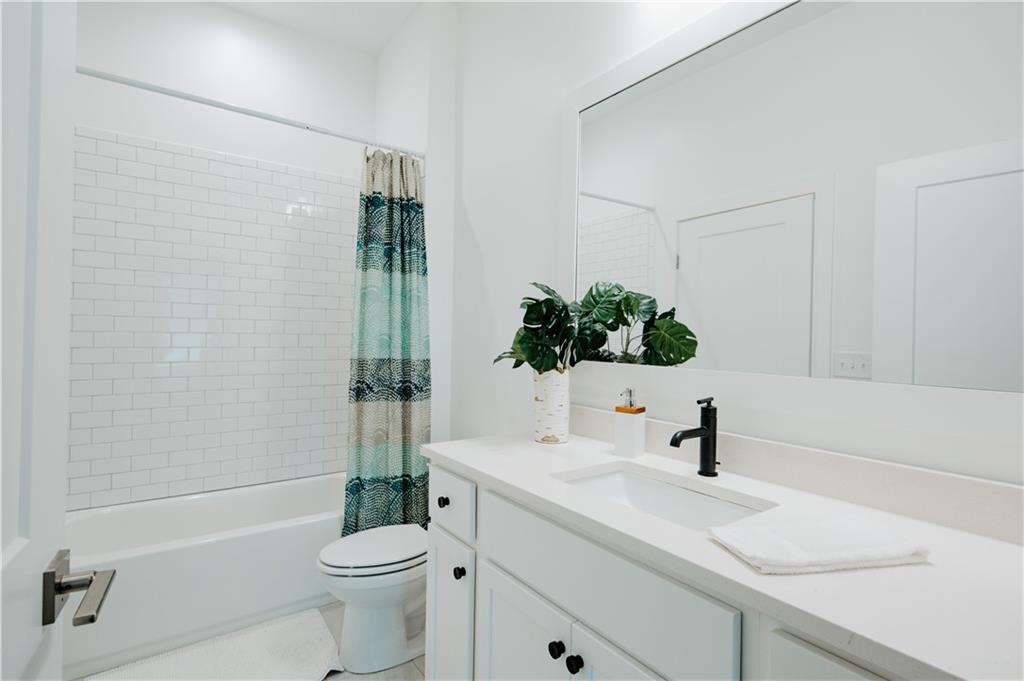 123 Mayson Avenue Northeast, Unit C Atlanta, GA 30307 - Photo 9 of 21 a bathroom with a sink a toilet a mirror a vanity and shower