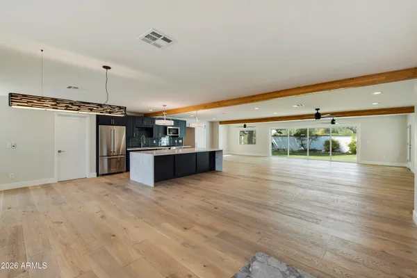 a large kitchen with stainless steel appliances kitchen island granite countertop a large counter top and wooden floors