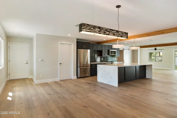 a kitchen with stainless steel appliances granite countertop a refrigerator a oven a sink with island and chairs