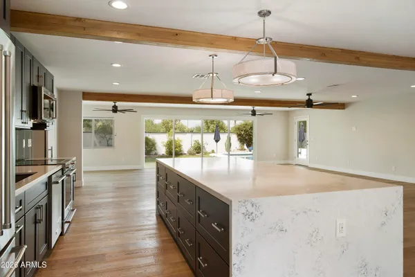 a kitchen with stainless steel appliances kitchen island granite countertop a stove a sink and a refrigerator