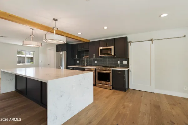 a large kitchen with granite countertop a stove and a sink