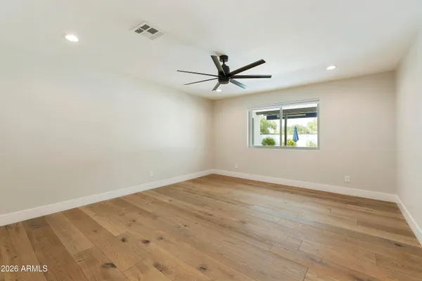 a view of a livingroom with a chandelier fan and windows