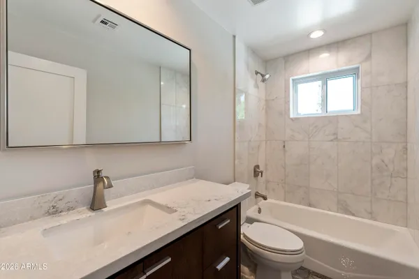 a bathroom with a granite countertop sink mirror and toilet