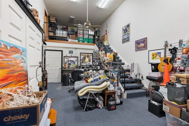 a utility room with furniture a rug toys and a book shelf