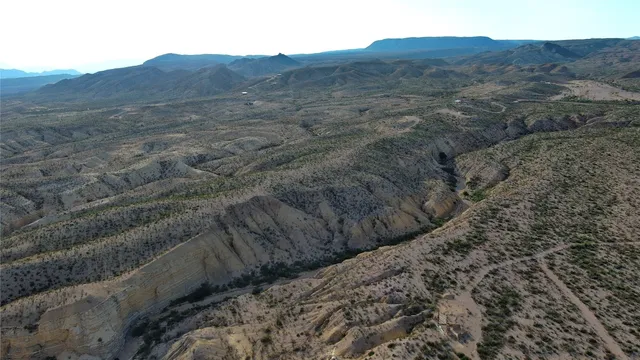 a view of a dry yard with mountains in the background