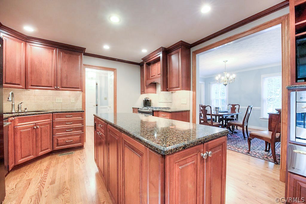 12808 Rivers Bend Road Chester, VA 23836 - Photo 18 of 41 a kitchen with kitchen island granite countertop wooden cabinets a counter top space and stainless steel appliances