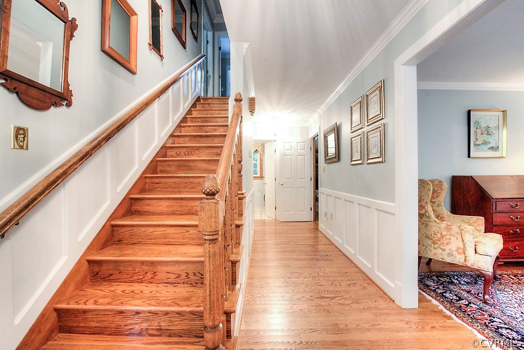 12808 Rivers Bend Road Chester, VA 23836 - Photo 9 of 41 a view of staircase with lots of frames on wall and wooden floor