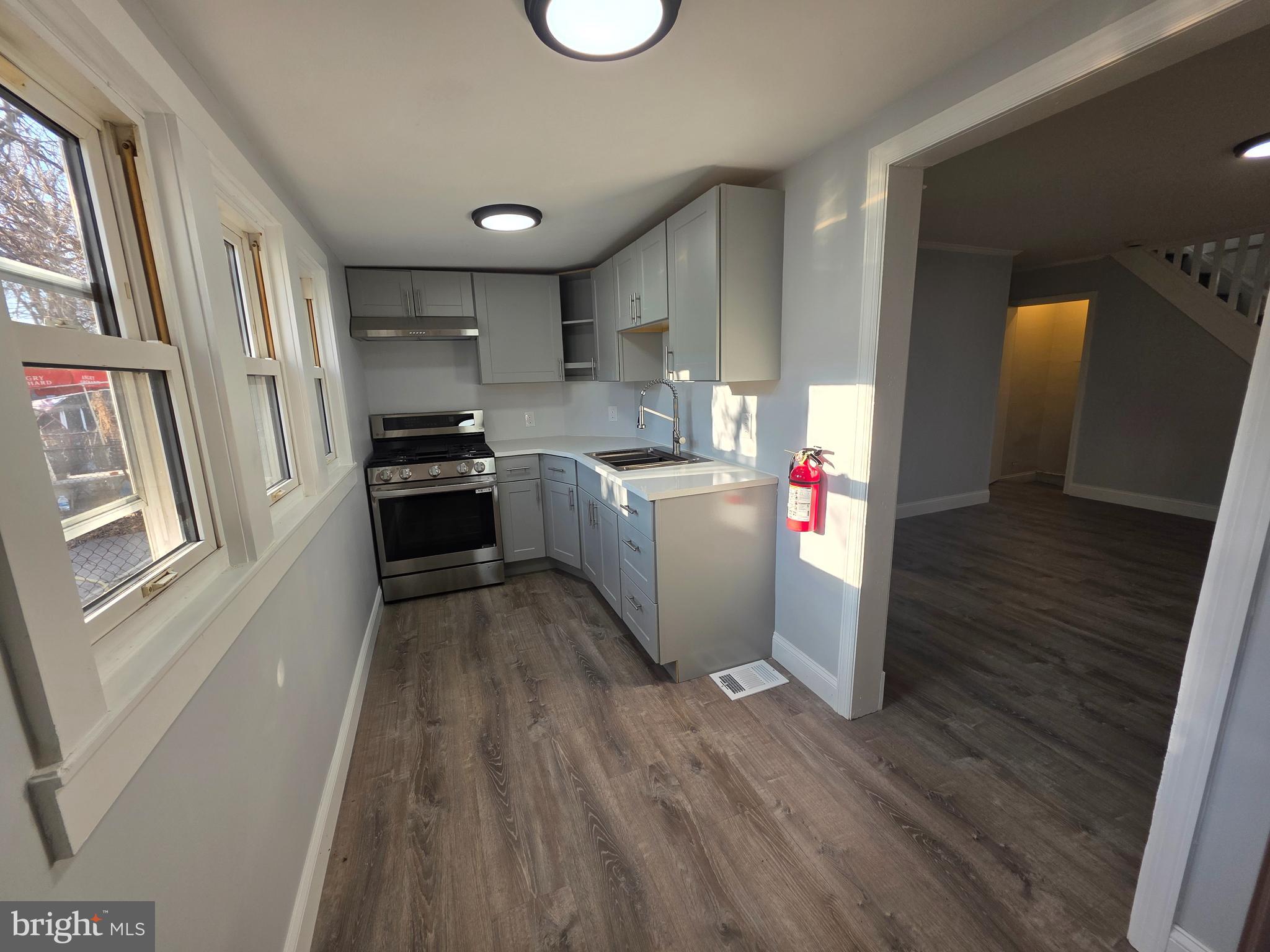 340 Middlesex Street Gloucester City, NJ 08030 - Photo 8 of 17 a kitchen with stainless steel appliances granite countertop a refrigerator a sink dishwasher a stove and white countertops with wooden floor