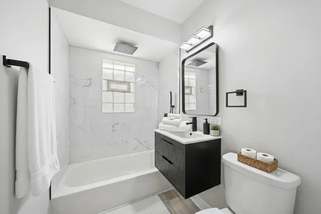 a bathroom with a tub sink toilet and mirror