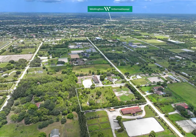 an aerial view of residential houses with outdoor space and trees