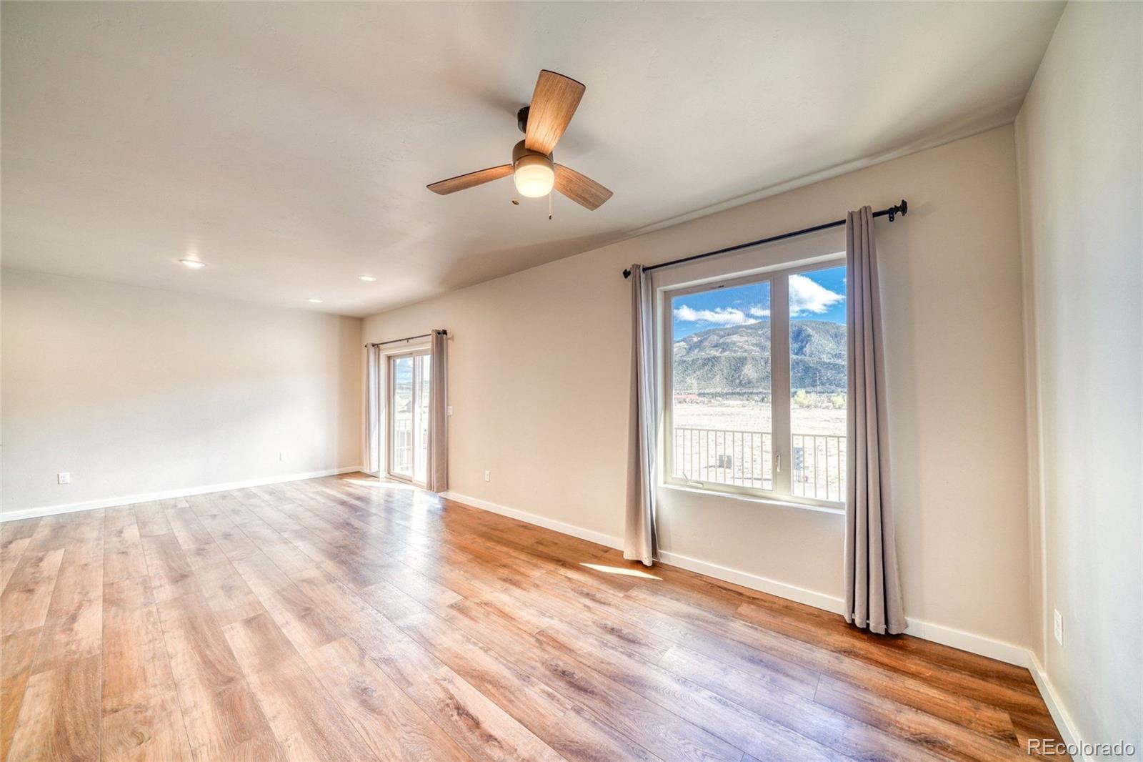 209 Summitview Lane Poncha Springs, CO 81201 - Photo 23 of 44 an empty room with wooden floor chandelier and windows