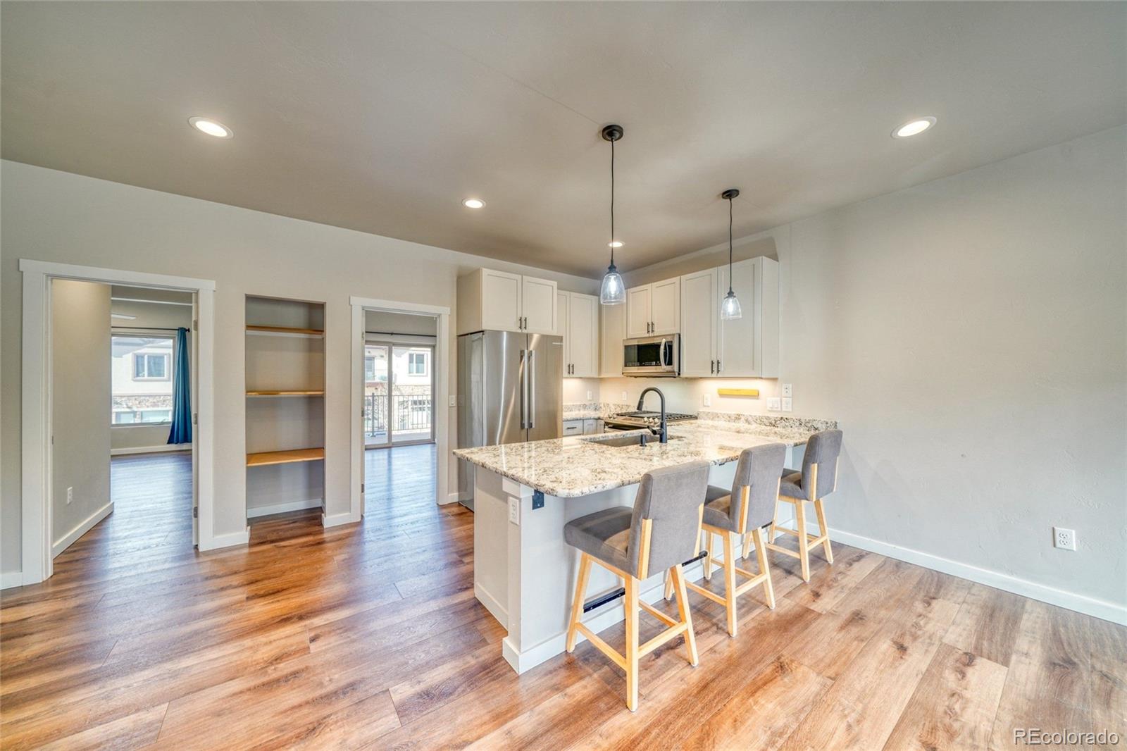 209 Summitview Lane Poncha Springs, CO 81201 - Photo 25 of 44 a kitchen with stainless steel appliances a stove a sink a refrigerator and white cabinets with wooden floor