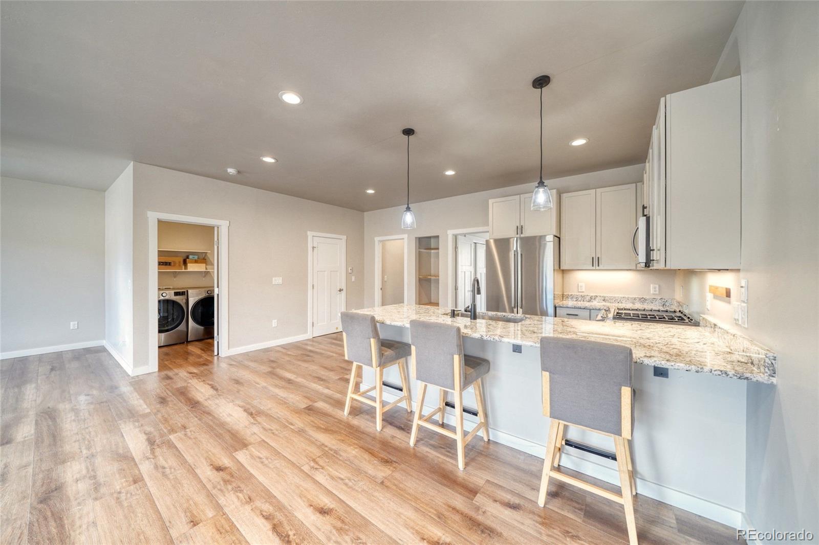 209 Summitview Lane Poncha Springs, CO 81201 - Photo 26 of 44 a large kitchen with cabinets chairs and wooden floor