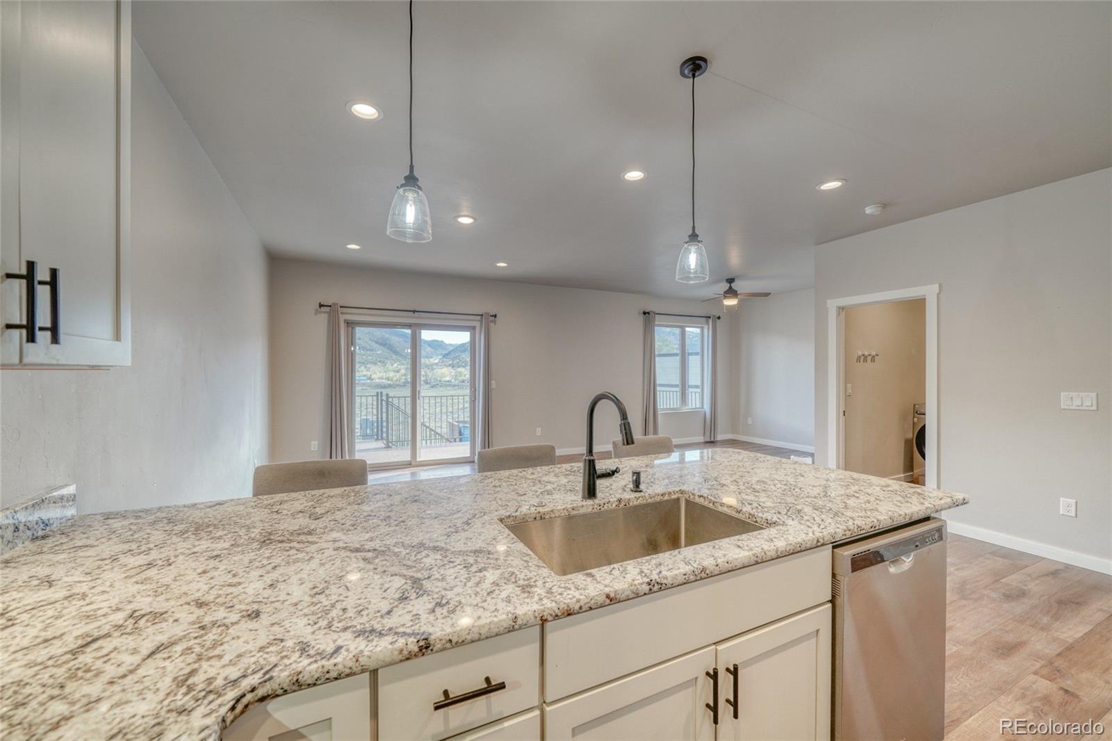209 Summitview Lane Poncha Springs, CO 81201 - Photo 30 of 44 a kitchen with stainless steel appliances granite countertop a sink dishwasher and refrigerator with wooden floor